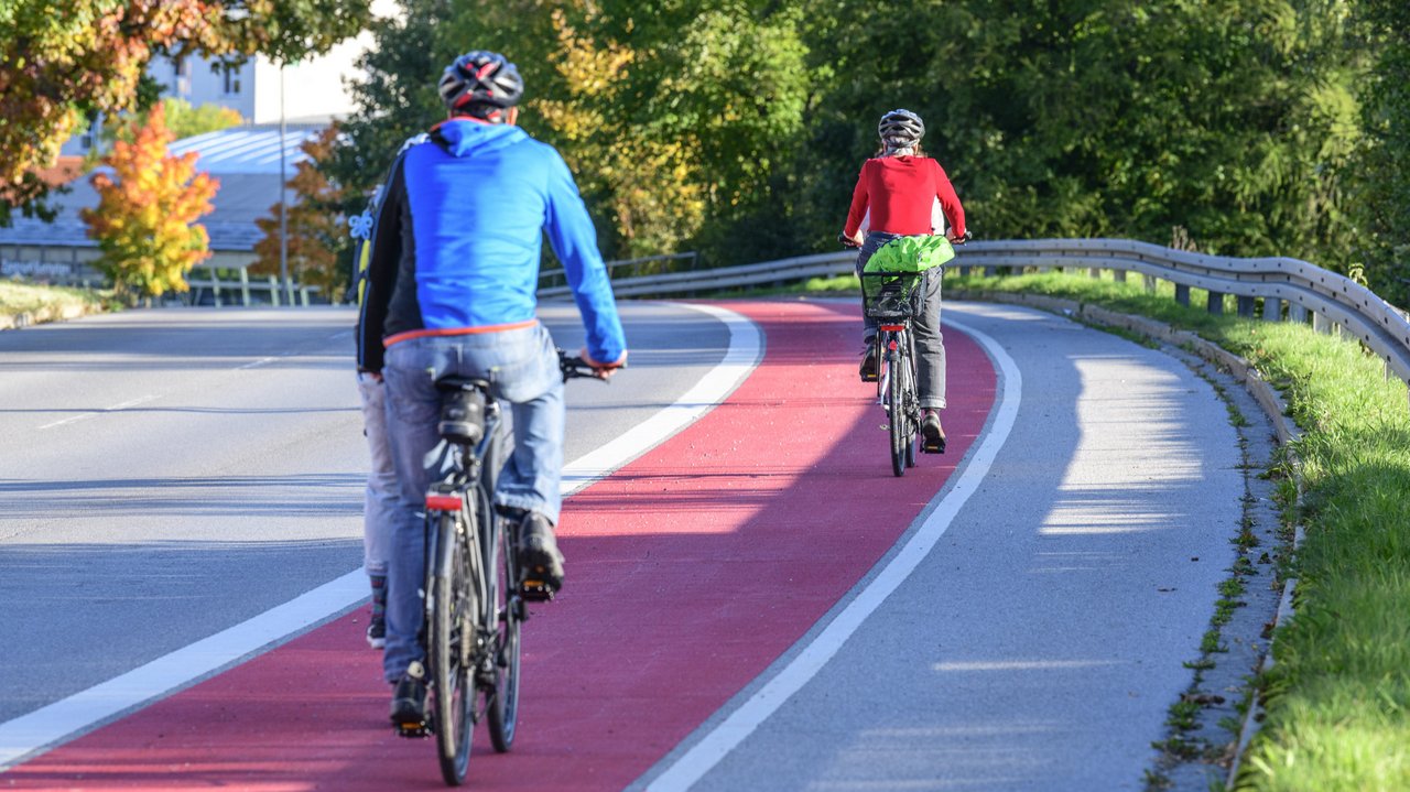 Zwei Fahrradfahrer auf dem Radweg Zwei Fahrradfahrer fahren auf einem rot gekennzeichneten Radweg. man sieht sie von hinten