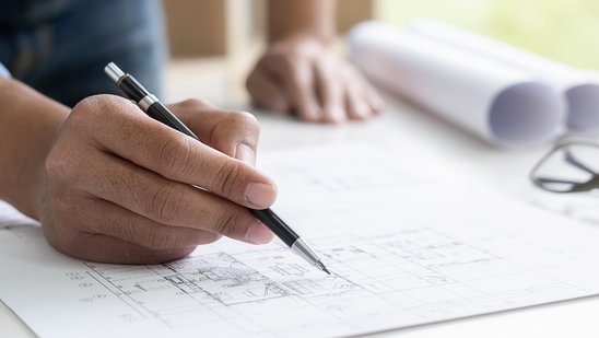 Ingenieur, der im Büro an Bauplan arbeitet