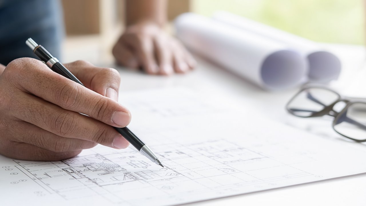 Ingenieur, der im Büro an Bauplan arbeitet