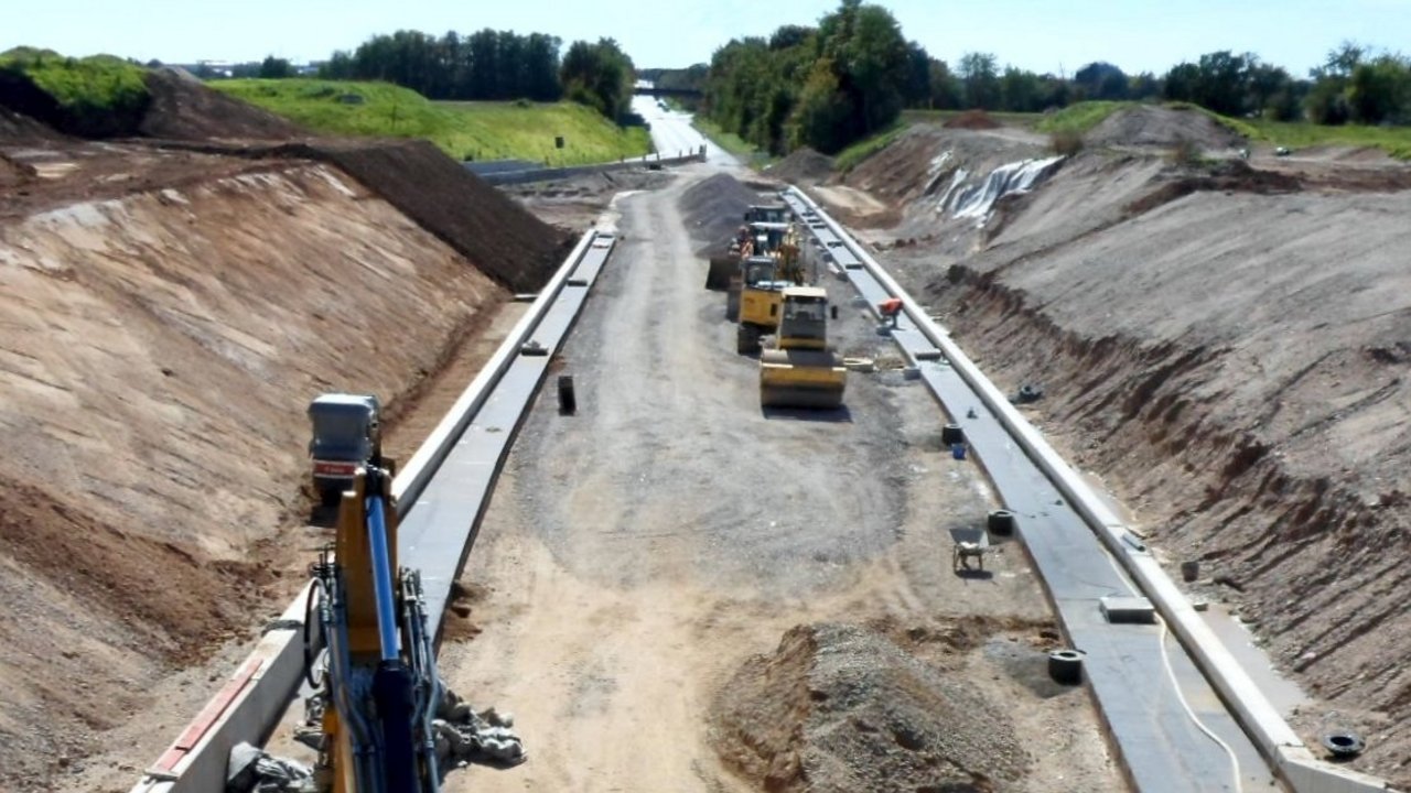 Bauaktivitäten am 30. November 2022 beim Teilprojekt Grundwasserwanne Das Foto zeigt die Bauaktivitäten vom 30.11.2022. Das heißt einen nicht mehr aktuellen Bauzustand. Es werden auf dem Foto vorbereitende Arbeiten erledigt, damit das Ingenieurbauwerk, das U-förmige Trogbauwerk aus Beton, gebaut werden kann. Im hinteren Teil des Fotos ist der Einbau der Naturschotterschicht auf der bis zu 2,20 Meter mächtigen Unterwasserbetonschicht zu erkennen. Im vorderen Teil des Fotos ist die fertige Unterwasserbetonschicht zu erkennen. Das Grundwasser wurde in dem Bereich noch nicht abgepumpt.