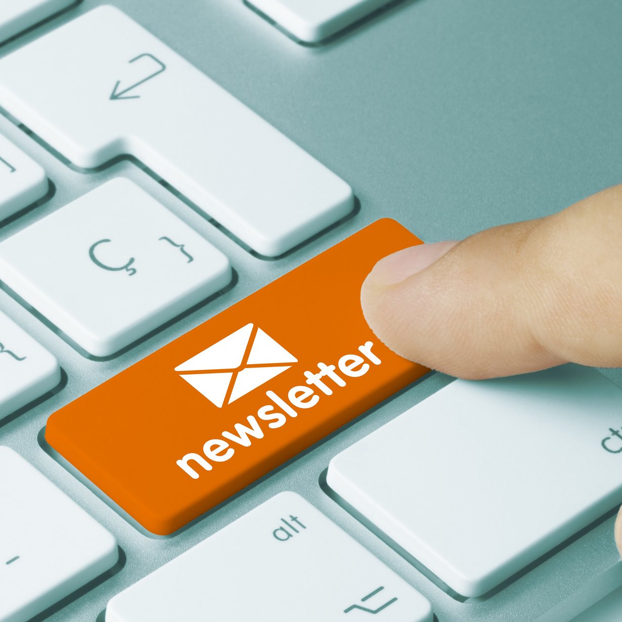 Ein Finger tippt auf die Taste "Newsletter" auf der Tastatur.