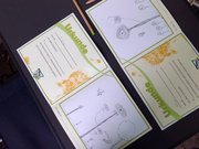 Zu sehen sind zwei aufgeklappte Ökomobil-Urkunden mit Zeichnungen der Kinder. 