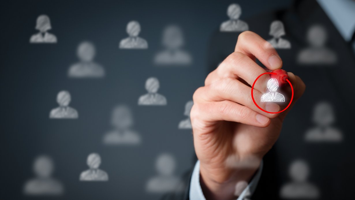 Männliche Hand, die mit einem roten Stift auf einer Glasscheibe einen Kreis um eine virtuelle Person zeichnet