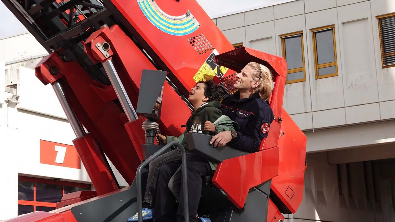 HEISS AUF LESEN-Gewinner Kian mit Feuerwehrmann Rocco Abt am Steuer der Drehleiter der Berufsfeuerwehr Pforzheim 
