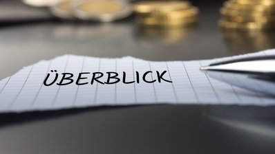 Zettel mit der Beschriftung "Überblick" und ein Stift
