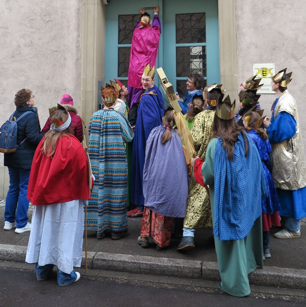 Sternsinger beim Anbringen des Segensspruchs