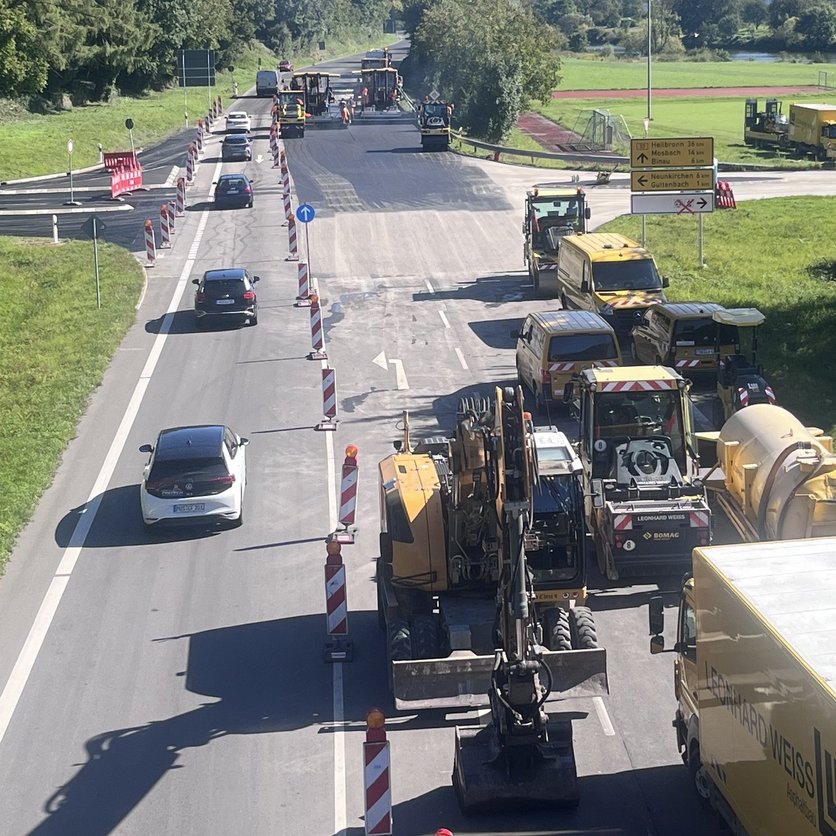 Es ist die Straße beim Asphalteinbau zu sehen