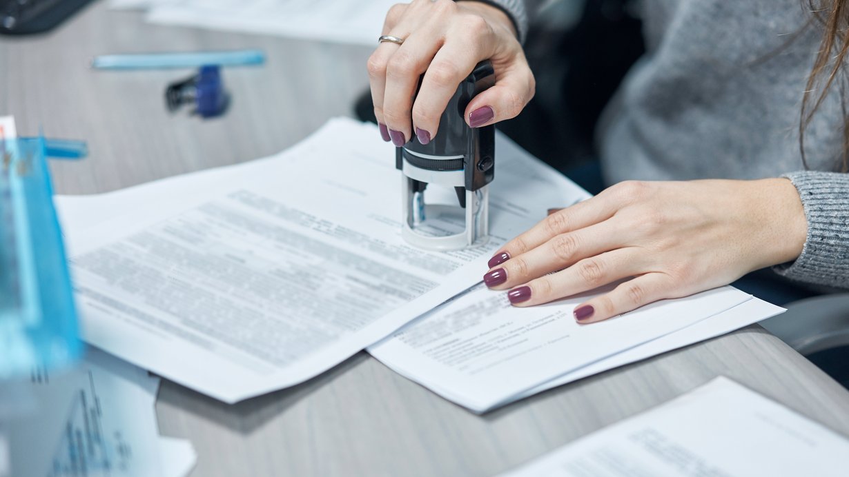 Eine Frau stempelt ein Blatt Papier