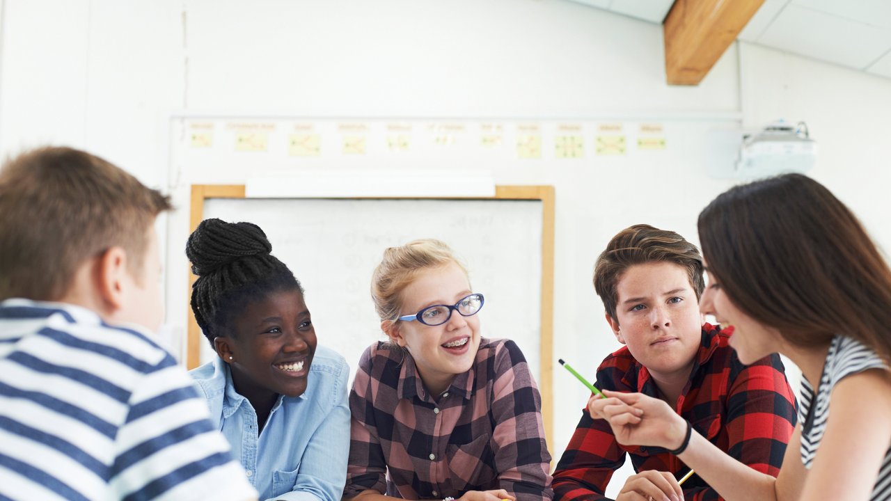 Schülerinnen und Schüler arbeiten gemeinsam an einem Projekt im Klassenraum