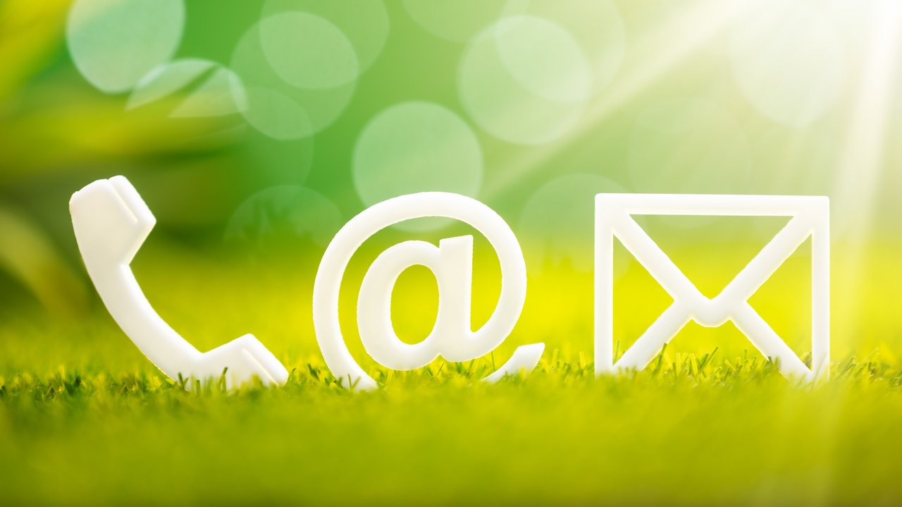 Kontakticons auf Gras Weiße Kontakticons (Telefon, E-Mail, Briefumschlatg) auf Gras
