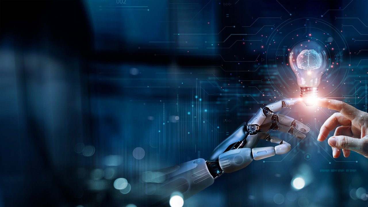 In der Mitte des Bildes ist eine Glühbirne zu sehen, die rechts und links von einer menschlichen und einer Roboterhand mit dem Finger angetippt wird. 