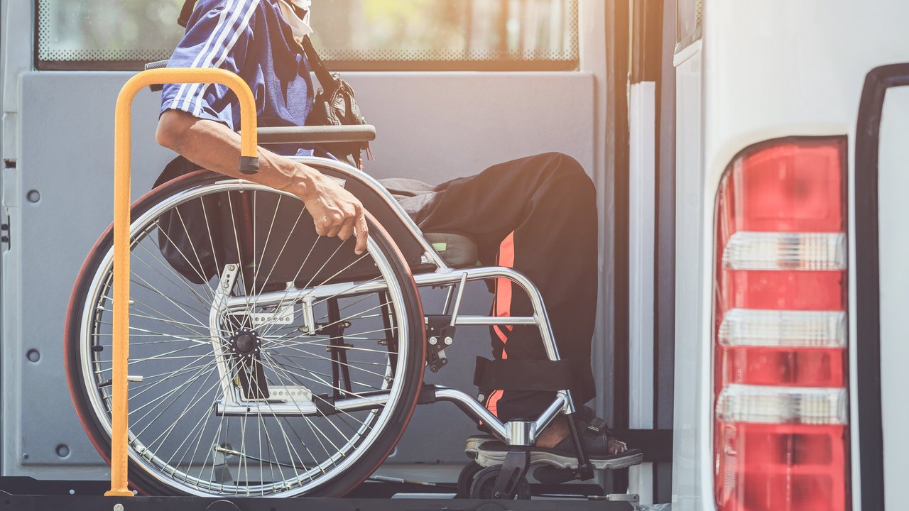 Rollstuhlfahrer der mit einer Hebebühne den Bus besteigen kann