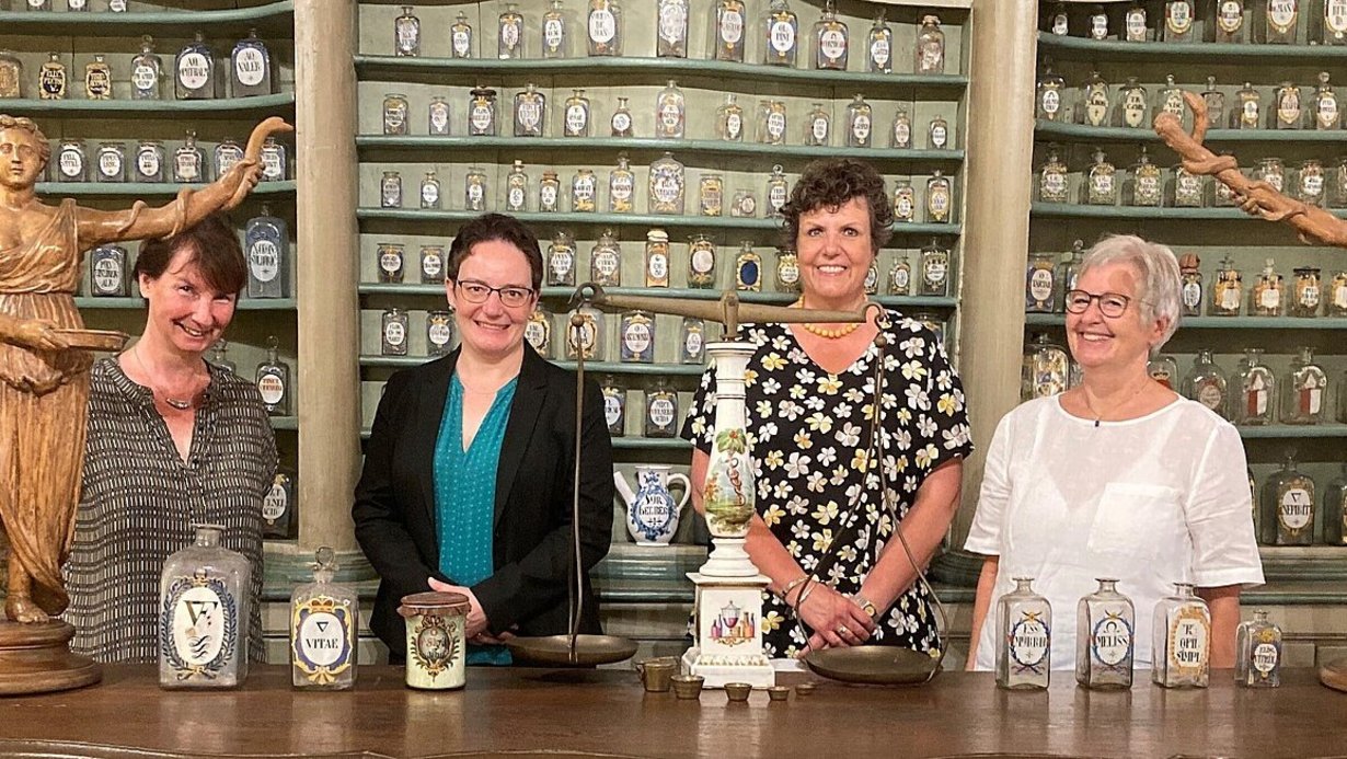 Regierungspräsidentin Sylvia M. Felder informiert sich im Deutschen Apotheken-Museum über die Arbeit der ehrenamtlichen Pharmazierätinnen und -räte. 