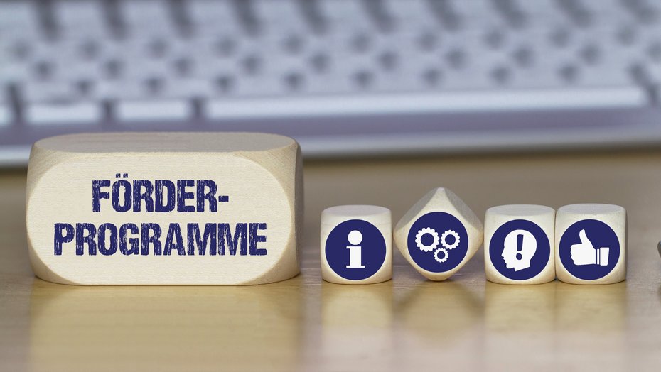 Symbolbild Förderprogramme Verschiedene Würfel mit Symbolbildern für Idee, Information, Daumen nach oben und mit dem Schriftzug Förderprogramme