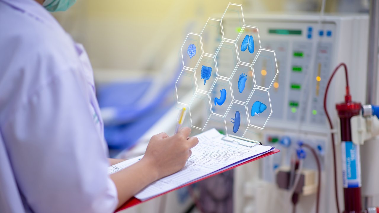 Frau steht mit Stift und Schreibblock vor einem medizinischen Diagnostikgerät