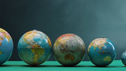 Weltkugeln in unterschiedlicher Größe in einer Reihe