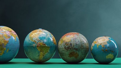 Weltkugeln in unterschiedlicher Größe in einer Reihe