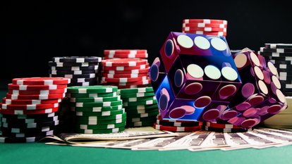 Glücksspiel Bunte Würfel, Spielchips, Karten auf grüner Oberfläche