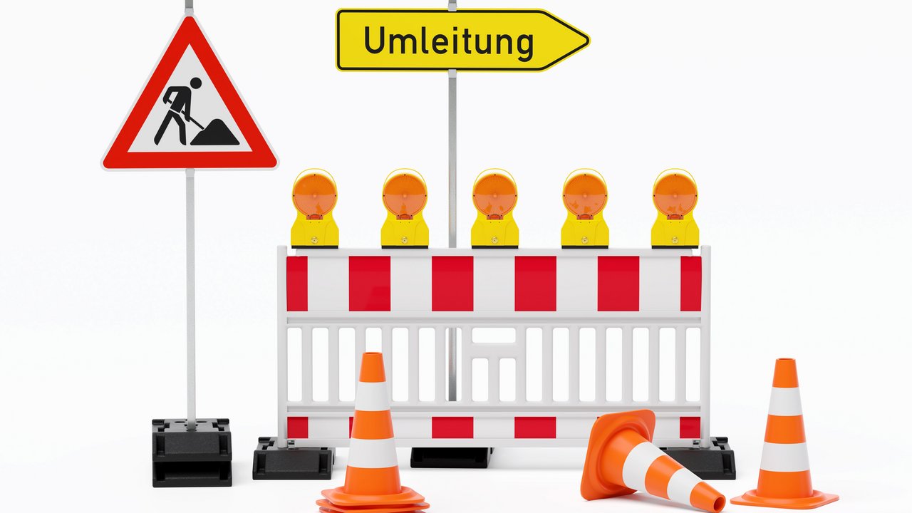 Einzelne Absturzsicherung mit 5 Bakenleuchten gelb-orange, Fußplatten, Schild Baustelle, Schild Umleitung rechtsweisend auf Pfosten steht daneben und Verkehrshütchen Pylone - freigestellt 