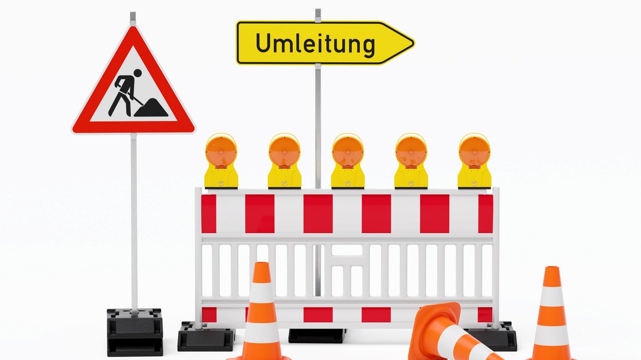 Einzelne Absturzsicherung mit 5 Bakenleuchten gelb-orange, Fußplatten, Schild Baustelle, Schild Umleitung rechtsweisend auf Pfosten steht daneben und Verkehrshütchen Pylone - freigestellt 