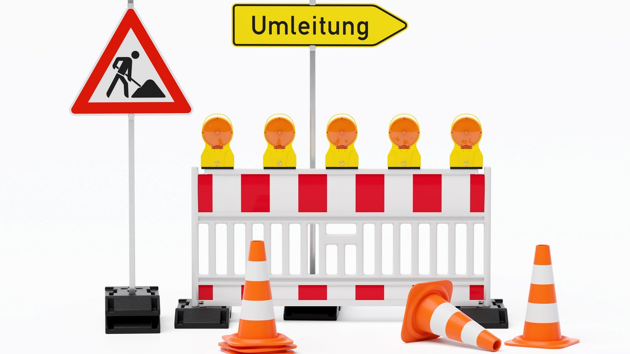 Einzelne Absturzsicherung mit 5 Bakenleuchten gelb-orange, Fußplatten, Schild Baustelle, Schild Umleitung rechtsweisend auf Pfosten steht daneben und Verkehrshütchen Pylone - freigestellt 