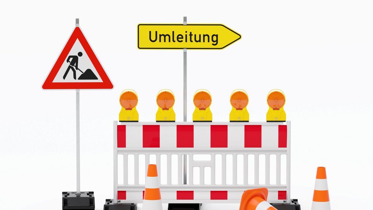 Einzelne Absturzsicherung mit 5 Bakenleuchten gelb-orange, Fußplatten, Schild Baustelle, Schild Umleitung rechtsweisend auf Pfosten steht daneben und Verkehrshütchen Pylone - freigestellt 