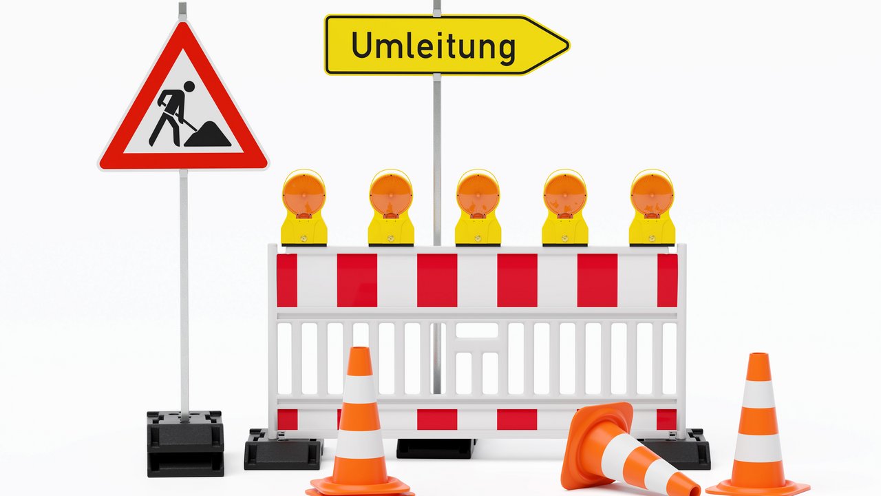 Einzelne Absturzsicherung mit 5 Bakenleuchten gelb-orange, Fußplatten, Schild Baustelle, Schild Umleitung rechtsweisend auf Pfosten steht daneben und Verkehrshütchen Pylone - freigestellt 