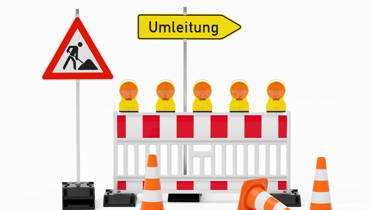 Einzelne Absturzsicherung mit 5 Bakenleuchten gelb-orange, Fußplatten, Schild Baustelle, Schild Umleitung rechtsweisend auf Pfosten steht daneben und Verkehrshütchen Pylone - freigestellt 