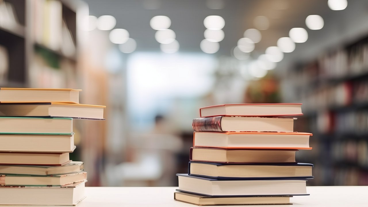 Zwei Stapel Bücher nebeneinander auf einem Tisch
