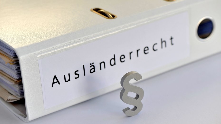 Ordner mit Beschriftung Ausländerrecht Ordner mit Beschriftung Ausländerrecht, davor Paragraphenzeichen