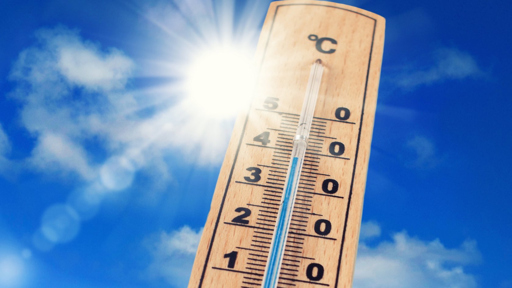 Thermometer mit Sonne im Hintergrund
